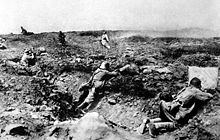 In the foreground three German soldiers behind cover engage attacking French soldiers