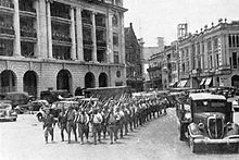 A parade of Japanese soldiers in a street of Singapore